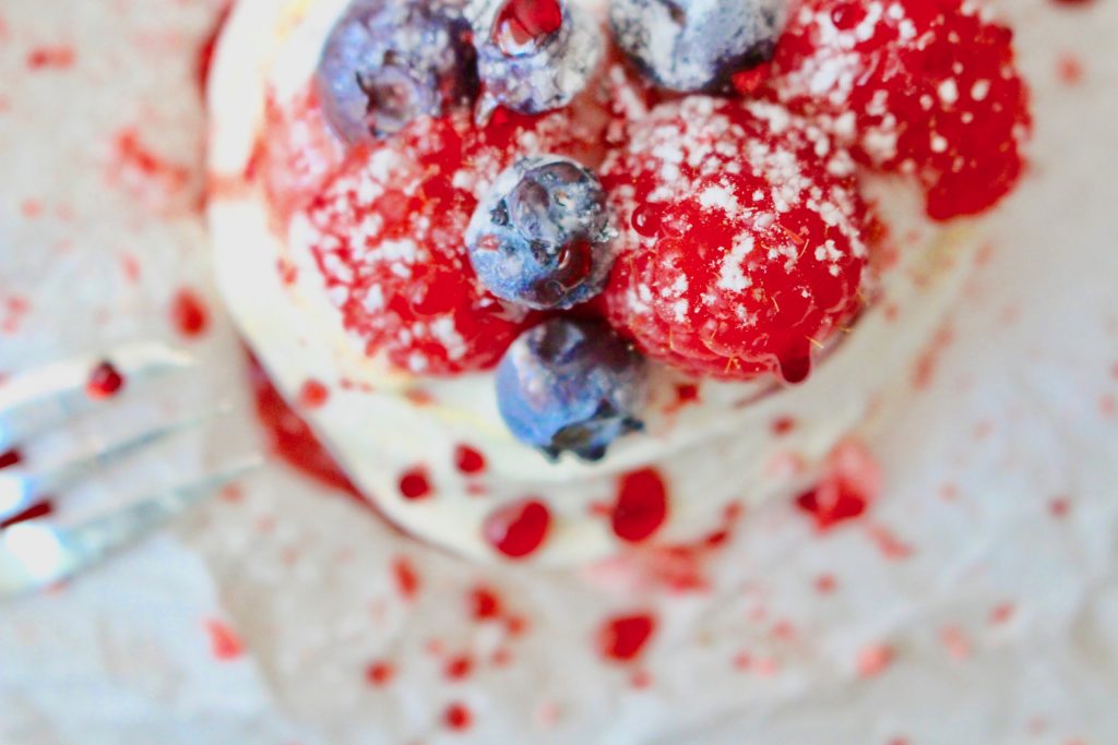 Mini Pavlova: meringue with whipped cream and berries. Dusted with powder sugar. Berry Nice!