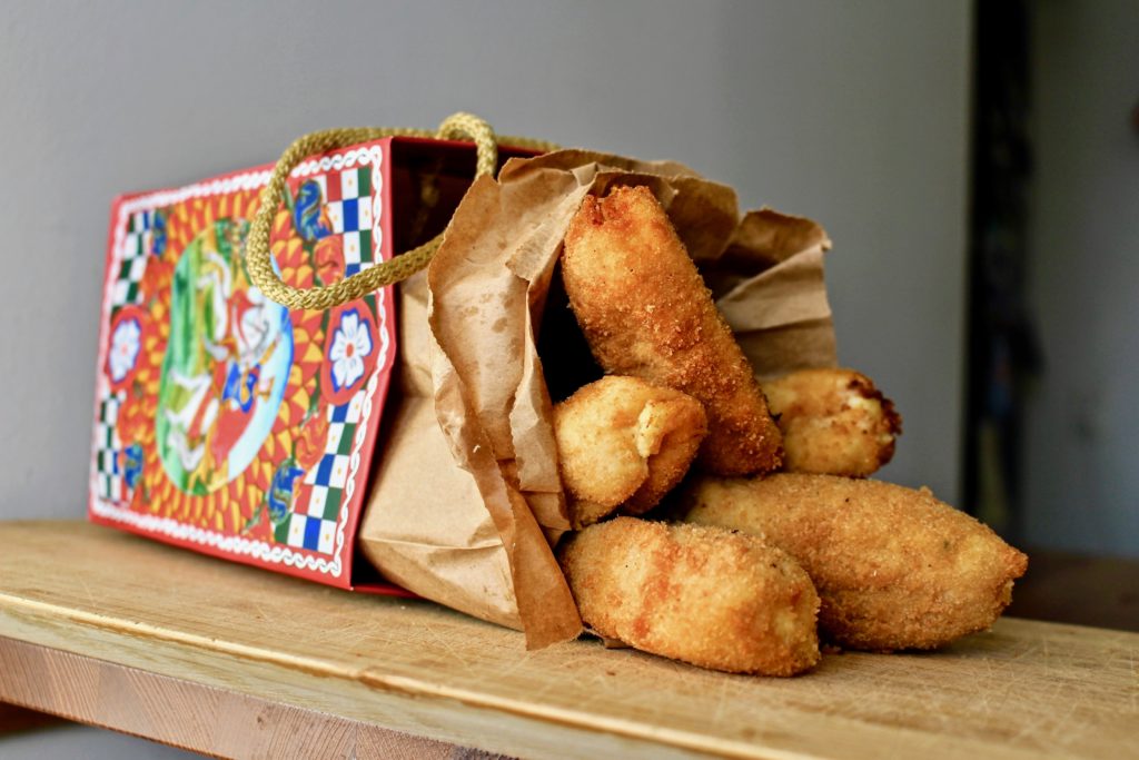 croquettes inside a paper bag with Sicilian drawings