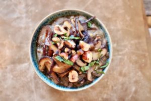 Lentil Miso soup with Shiitake mushrooms and hazelnuts served in a green bowl