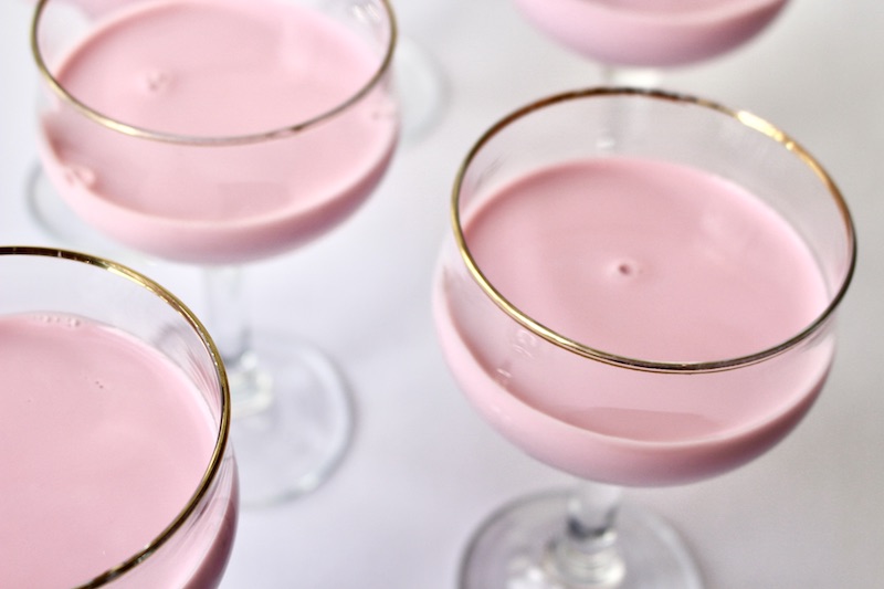 milk rose punch in a glass with gold trim