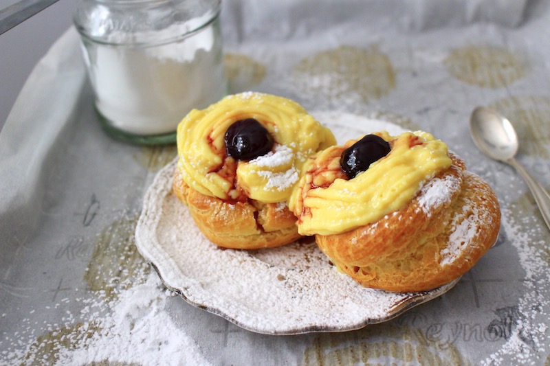 Zeppole di San Giuseppe filled with pastry cream and topped with an amarena cherry