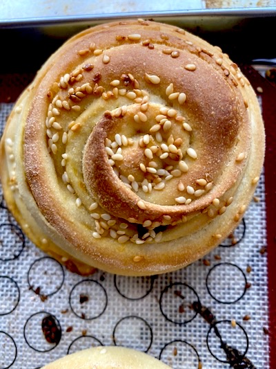 a rolled bun of Sicilian bread, golden brown crust and sesame seeds on top