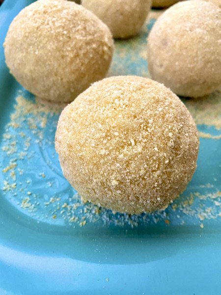 breaded arancine ready to be fried on a turquoise tray 